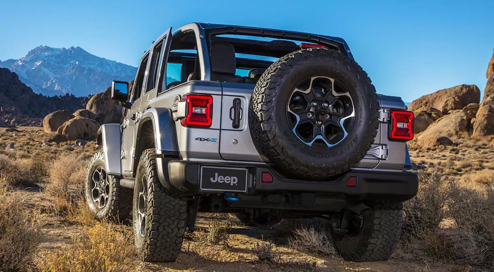 A silver 2021 Jeep Wrangler 4xe is shown off-roading in the desert.