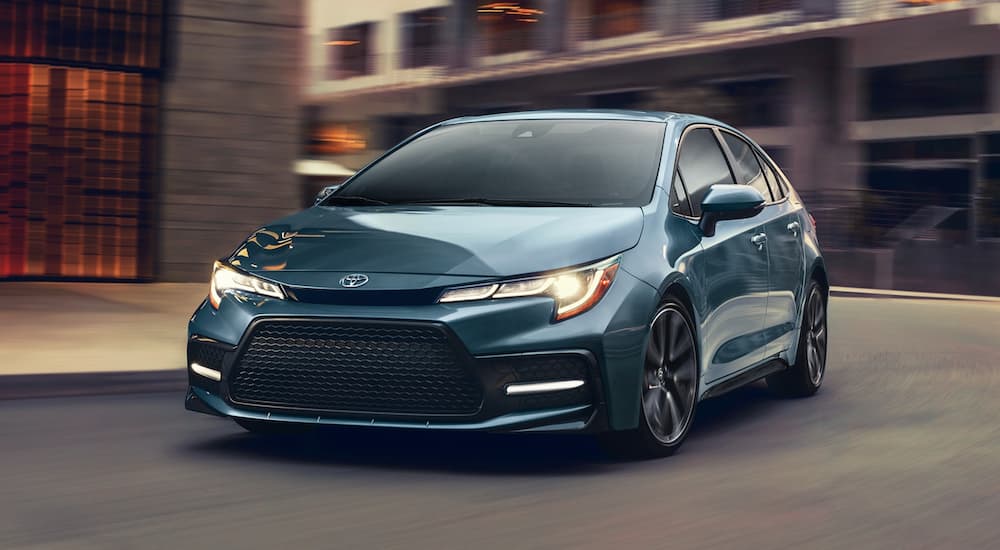 A blue 2020 Toyota Corolla XLE is shown turning onto a city street.