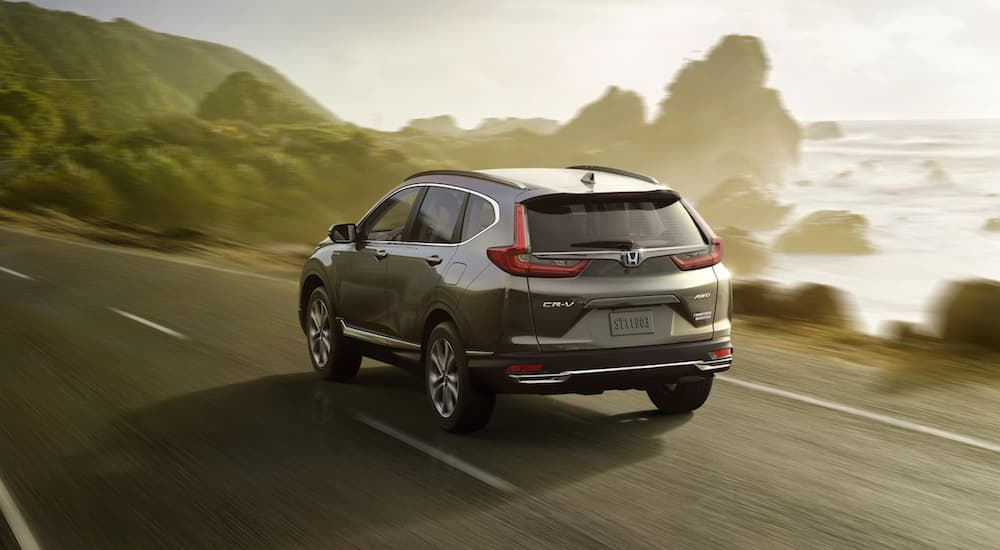 A grey 2021 Honda CR-V Hybrid is shown driving past a lake after winning a 2021 Honda CR-V vs 2021 Hyundai Tucson comparison.