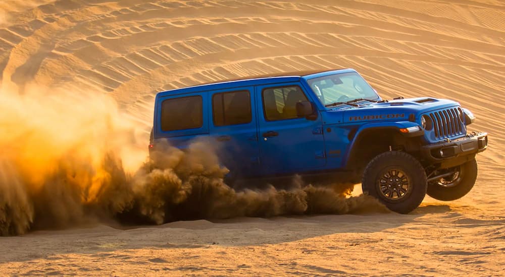 A blue 2021 Jeep Rubicon 392 edition is shown driving across a desert landscape.