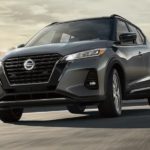 A grey 2021 Nissan Kicks is shown driving in a city after winning a 2021 Nissan Kicks vs 2021 Chevy Trax comparison.
