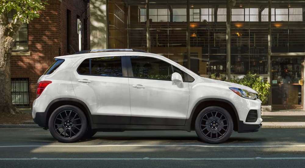 A white 2021 Chevy Trax is shown from the side parked on a city street.