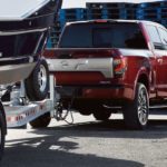 A red 2021 Nissan Titan XD is shown towing a boat.