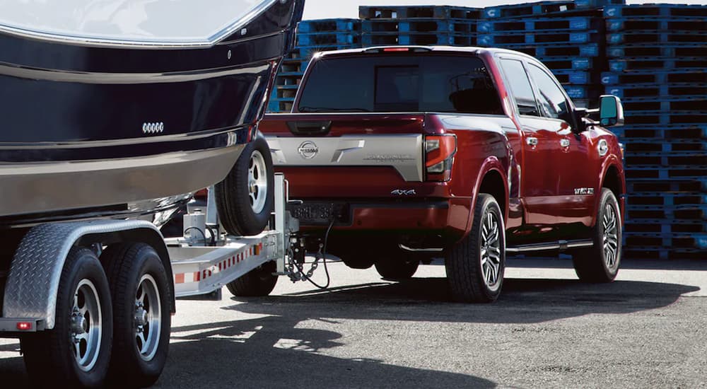 A red 2021 Nissan Titan XD is shown towing a boat.