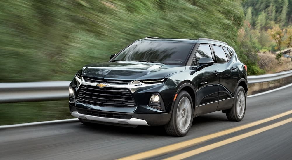 A black 2022 Chevy Blazer is shown from the front driving on an open road.