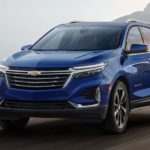 A blue 2022 Chevy Equinox is shown from the front driving on an open road after winning a 2022 Chevy Equinox vs 2022 Buick Envision comparison.