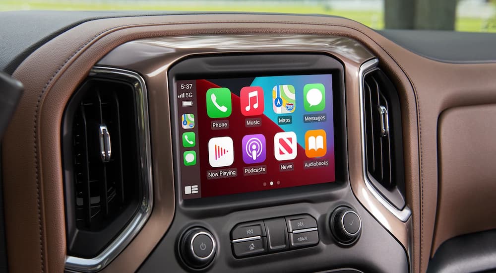 The black and brown interior of a 2022 Chevy Silverado 2500HD shows applications on the infotainment screen.