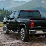 A black 2022 Chevy Silverado 2500HD LT is shown from the rear overlooking a mountain landscape.