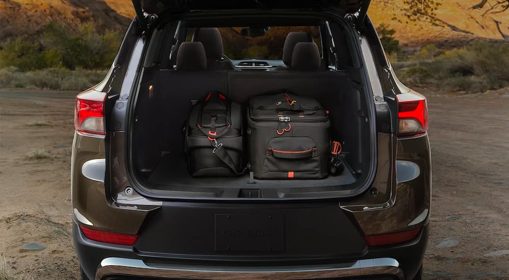 An open tailgate on a brown 2022 Chevy Trailblazer shows the rear cargo space.