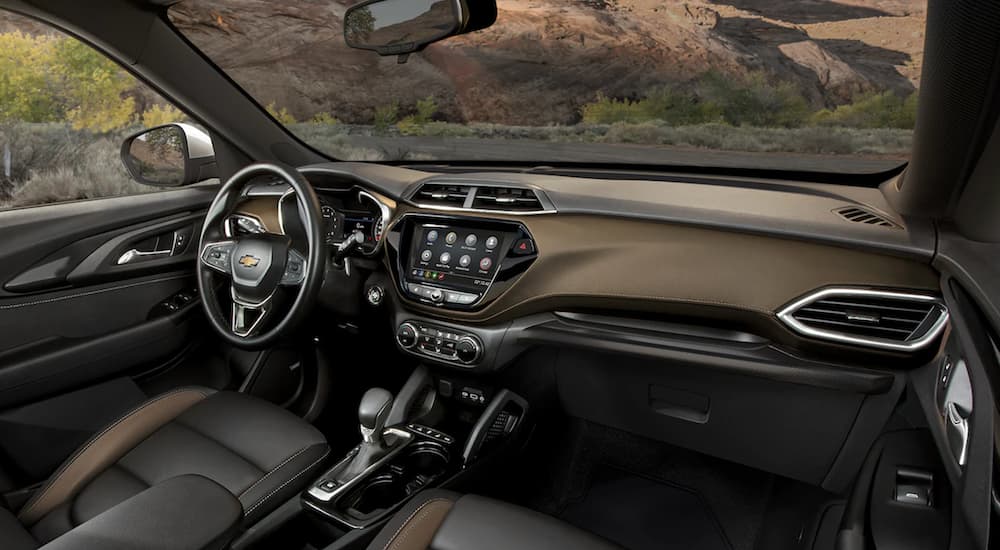 The gold interior of a 2022 Chevy Trailblazer shows the steering wheel and infotainment screen.