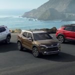 A bronze, a white, and a red 2022 Chevy Trailblazer are shown parked near a shore.