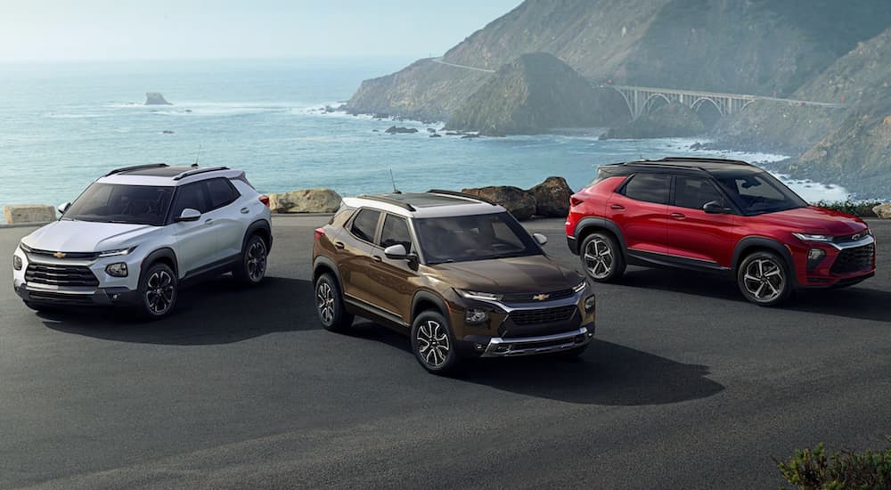 A bronze, a white, and a red 2022 Chevy Trailblazer are shown parked near a shore.