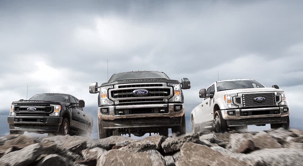 Three 2022 Ford Super Duties are shown from the front parked on rocks.