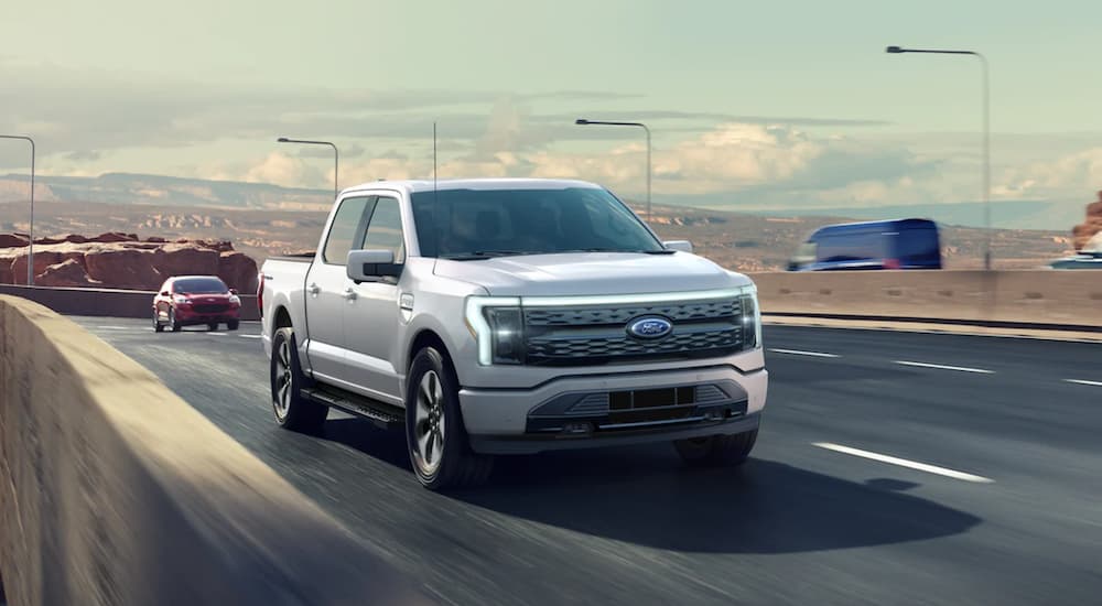 A grey 2022 Ford Lightning is shown from driving on the highway during a 2022 Ford Lightning vs 2022 Tesla Cybertruck comparison.