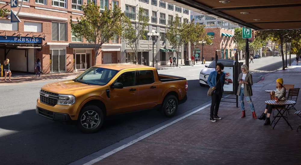 An orange 2022 Ford Maverick is shown parked on a city street after winning a 2022 Ford Maverick vs 2022 Hyundai Santa Cruz comparison.