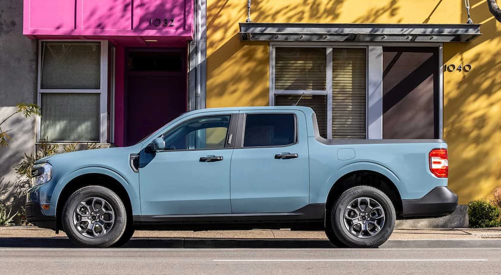 A blue 2022 Ford Maverick is shown from the side parked in a city.