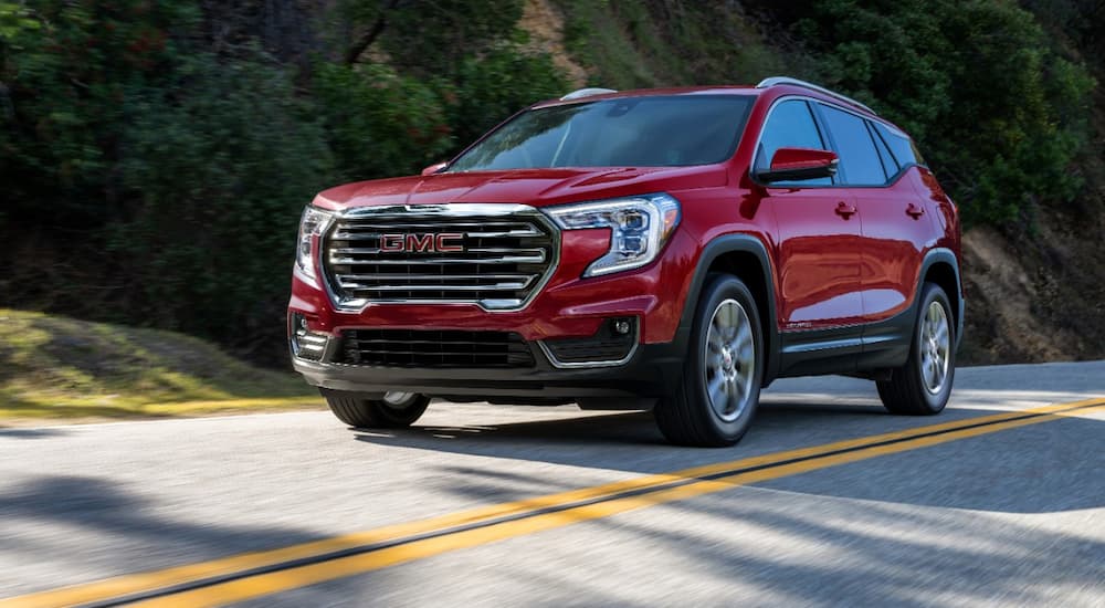 A red 2022 GMC Terrain SLT is shown from an angle driving down an empty road.