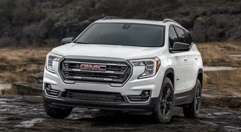 A white 2022 GMC Terrain is shown from the front off-roading through the mud.