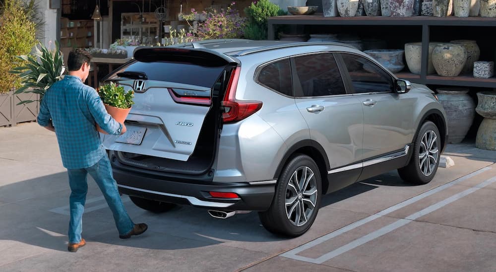 A man is shown opening the tailgate hands free on a silver 2022 Honda CR-V Touring.