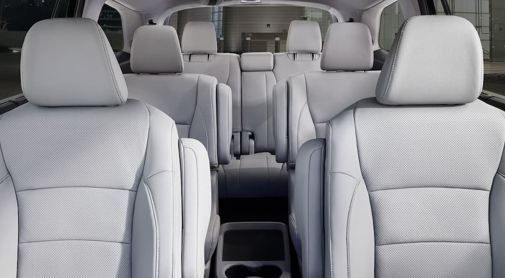 The grey leather interior of a 2022 Honda Pilot Elite shows the three rows of seating.