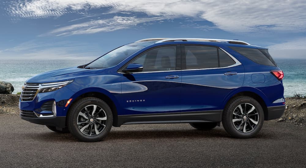 A blue 2022 Chevy Equinox is shown from the side parked in a lot during a 2022 Volkswagen Tiguan vs 2022 Chevy Equinox comparison.