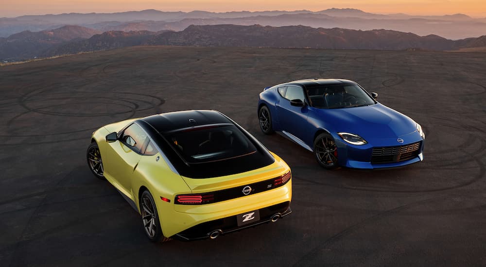 A blue and yellow 2023 Nissan Z are shown from a high angle in an empty parking lot.