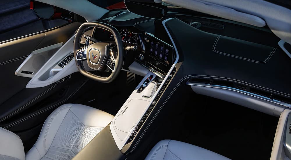 The white and black leather interior of a 2022 Chevy Corvette shows the steering wheel and center console.