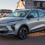 A silver 2022 Chevy Bolt EUV is shown from an angle parked in a driveway in front of a home.