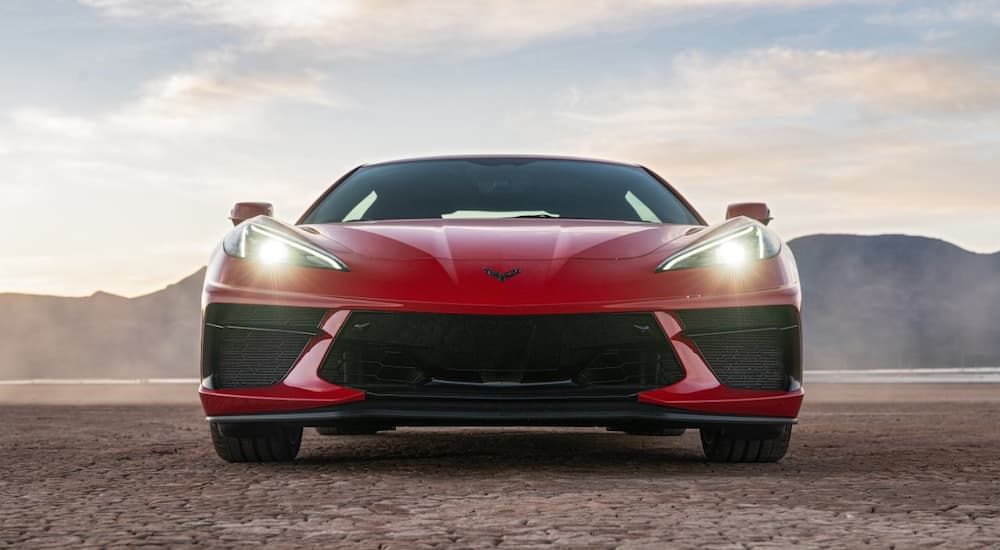 A red 2022 Chevy Corvette Stingray is shown from the front parked in a desert after visiting Chevy dealers.