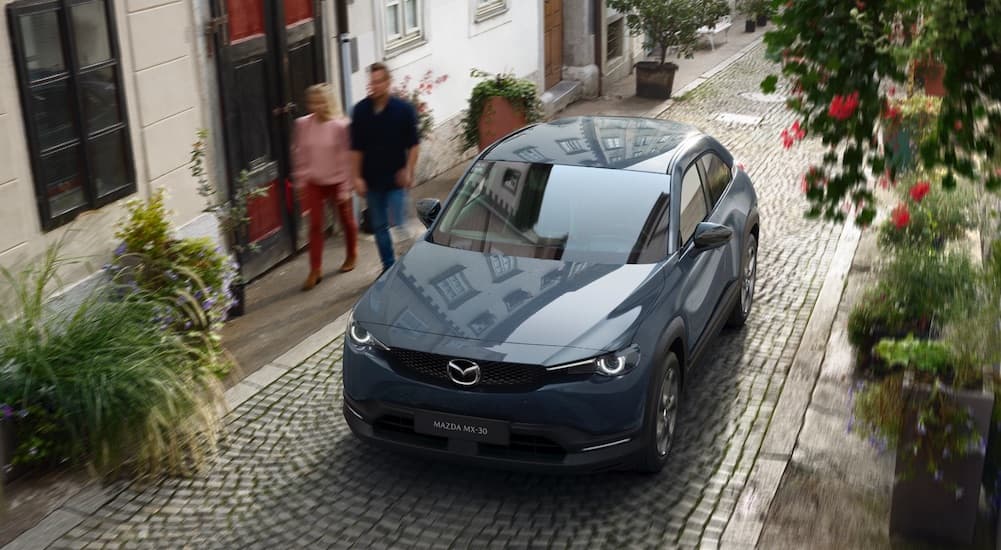 A grey 2022 Mazda MX-30 is shown from a high angle parked on a brick path.