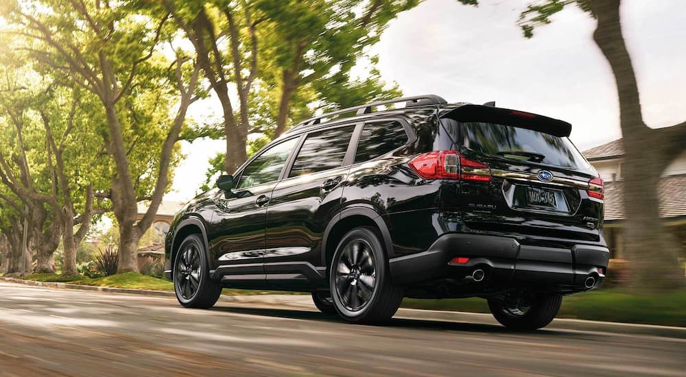 A black 2022 Subaru Ascent Onyx is shown from a rear angle driving near Subaru Ascent dealerships.