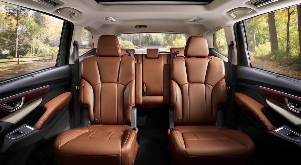 The brown interior of a 2022 Subaru Ascent shows the second and third row seats.