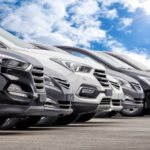 A line of used cars are shown at a used car dealership.