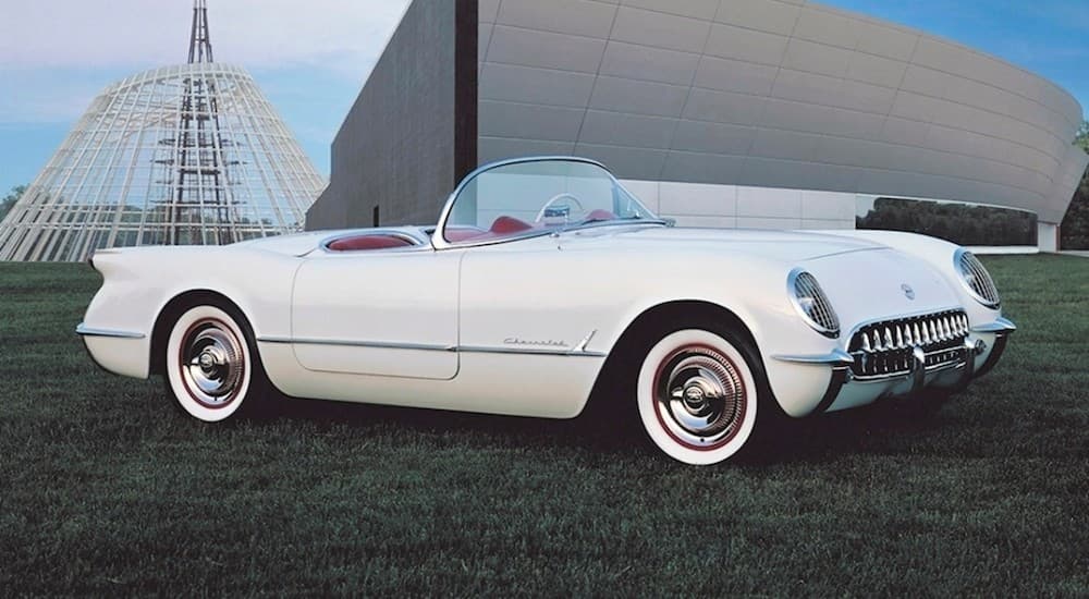 A white 1955 Chevy Corvette is shown from the side at a used Chevy dealer.