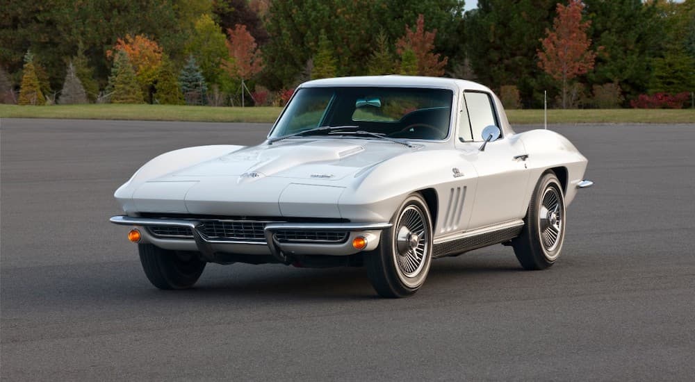 A white 1966 Chevy Corvette is shown from the front in an empty parking lot.