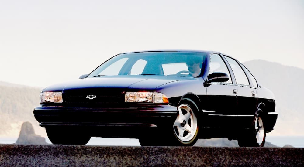 A black 1996 Chevy Impala SS is shown in an empty parking lot.