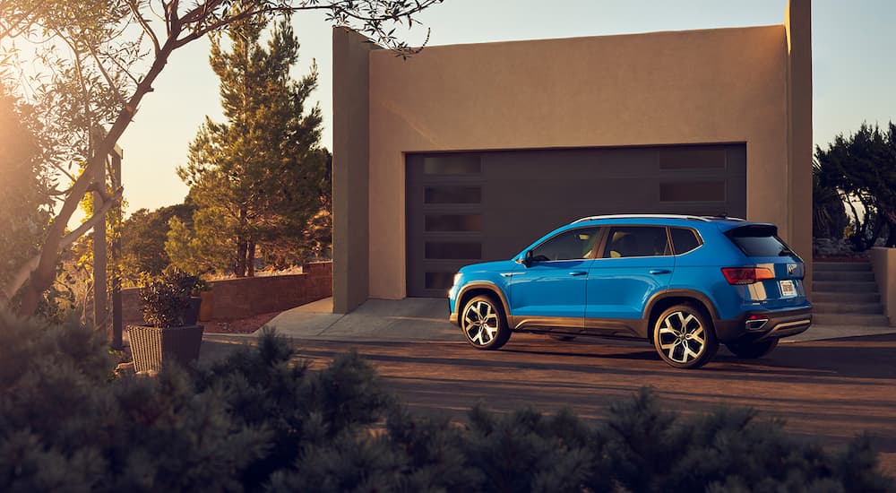 A blue 2022 Volkswagen Taos is shown parked in a driveway.