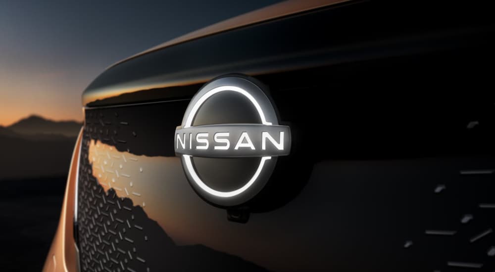 A black 2022 Nissan Aryiya shows the Nissan logo in close up.