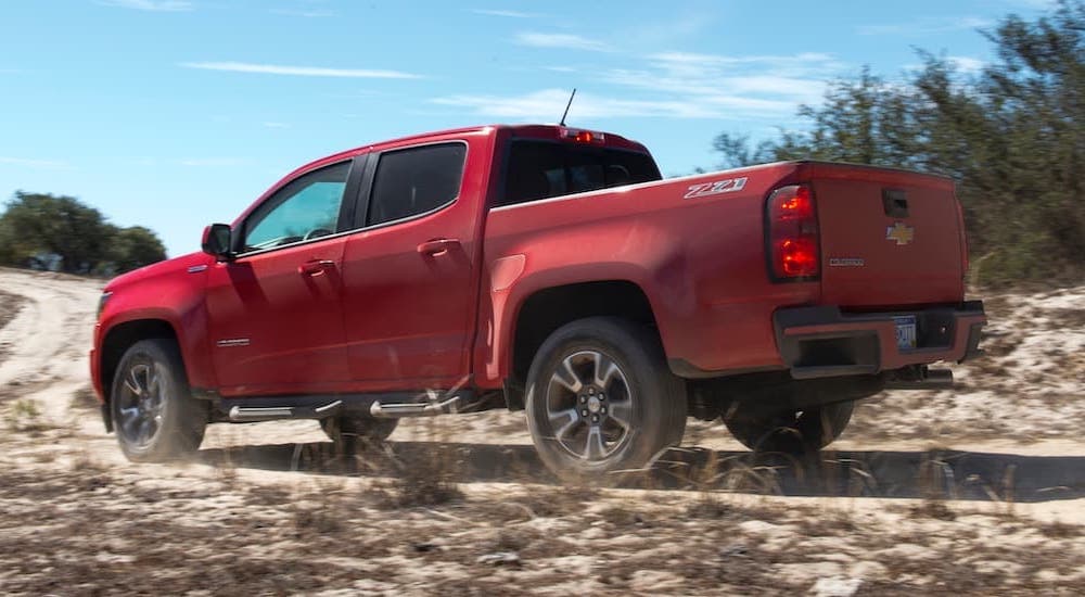 A red 2017 Chevy Colorado is shown from the side off-roading in a desert.