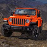 An orange 2019 Jeep Wrangler is shown from the front parked in the mountains after looking at a used Jeep Wrangler for sale.