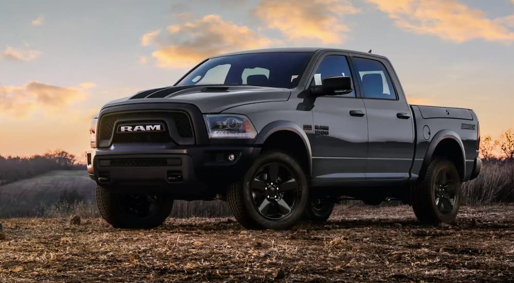 A black 2019 Ram 1500 is shown from the side parked in a field after looking at a used Ram 1500.