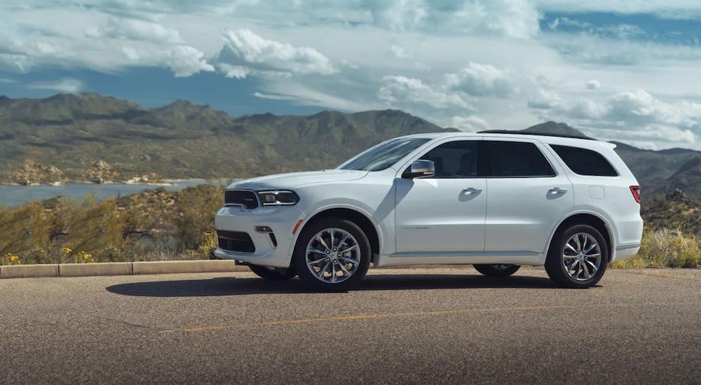A white 2021 Dodge Durango is shown from the side with distant mountains.