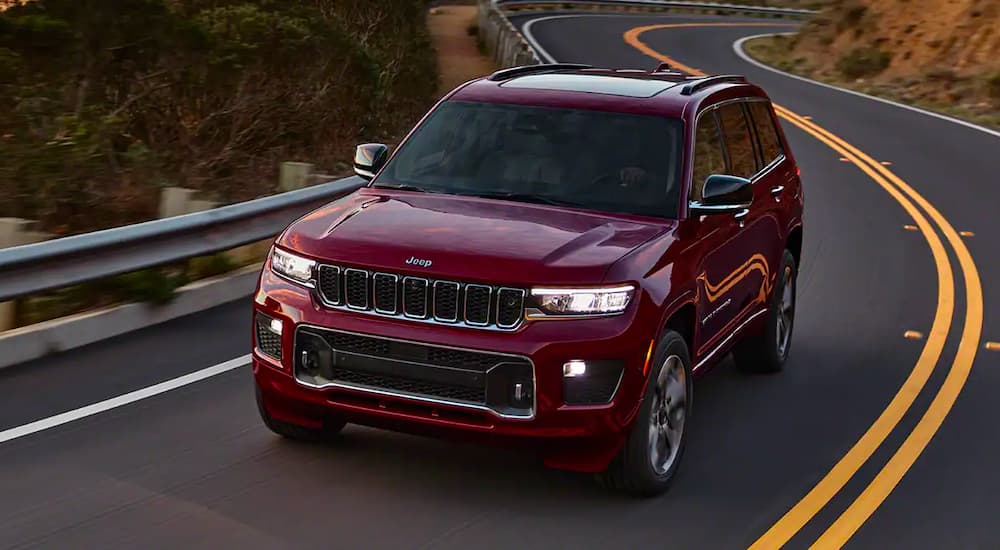 A red 2021 Jeep Grand Cherokee L is shown driving on a road after winning a 2021 Jeep Grand Cherokee L vs 2021 Dodge Durango face-off.