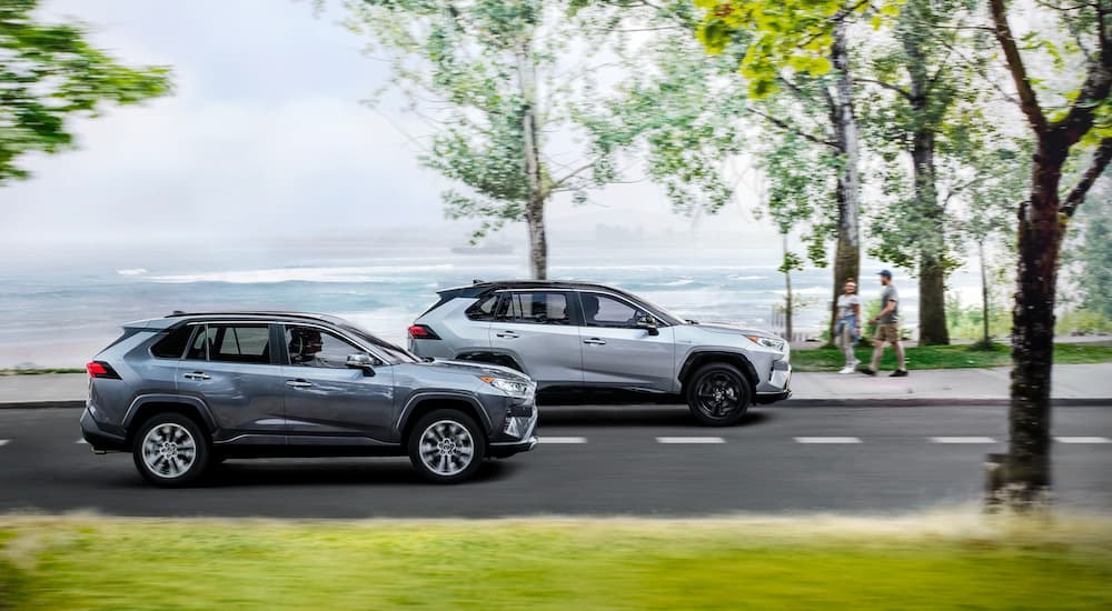 A blue 2021 Toyota RAV4 Limited is shown driving next to a silver XSE.