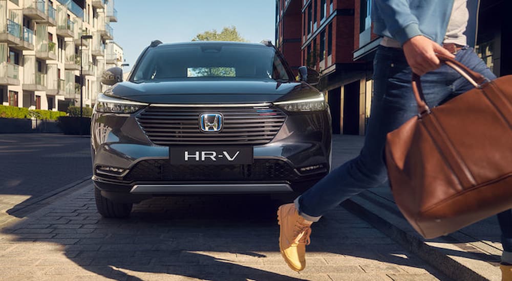 A woman is shown walking in front of a Honda HR-V Hybrid prototype.