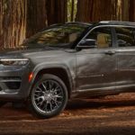 A grey 2022 Jeep Grand Cherokee is shown parked on a forest trail.