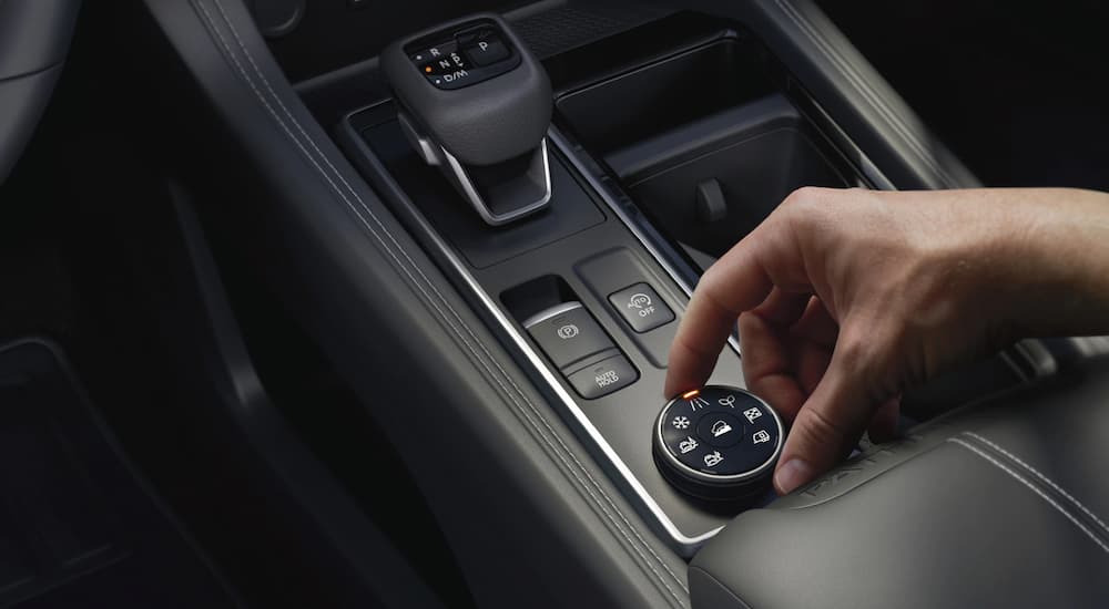 The center console of a 2022 Nissan Pathfinder shows the shifter and terrain modes knob.