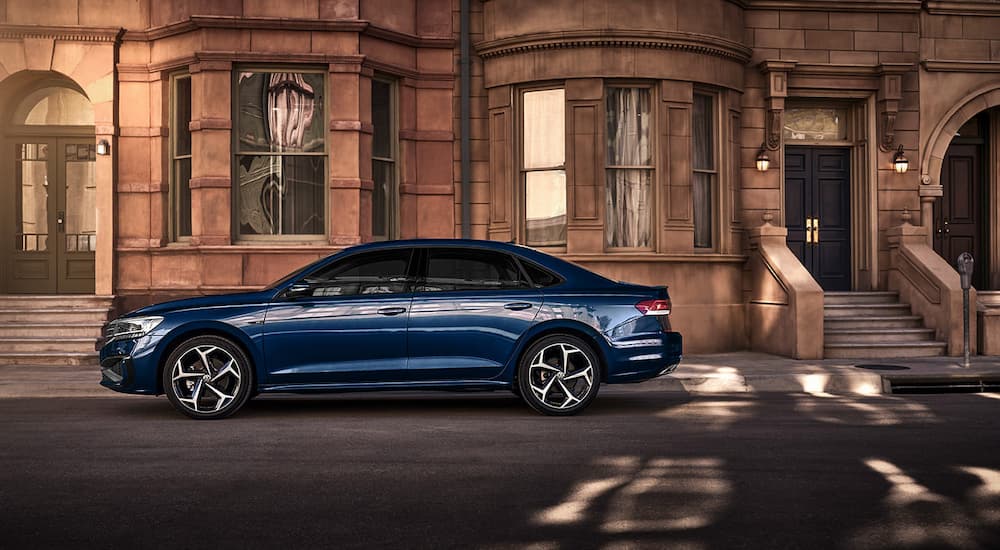 A blue 2022 Volkswagen Passat is shown from the side parked on a city street.