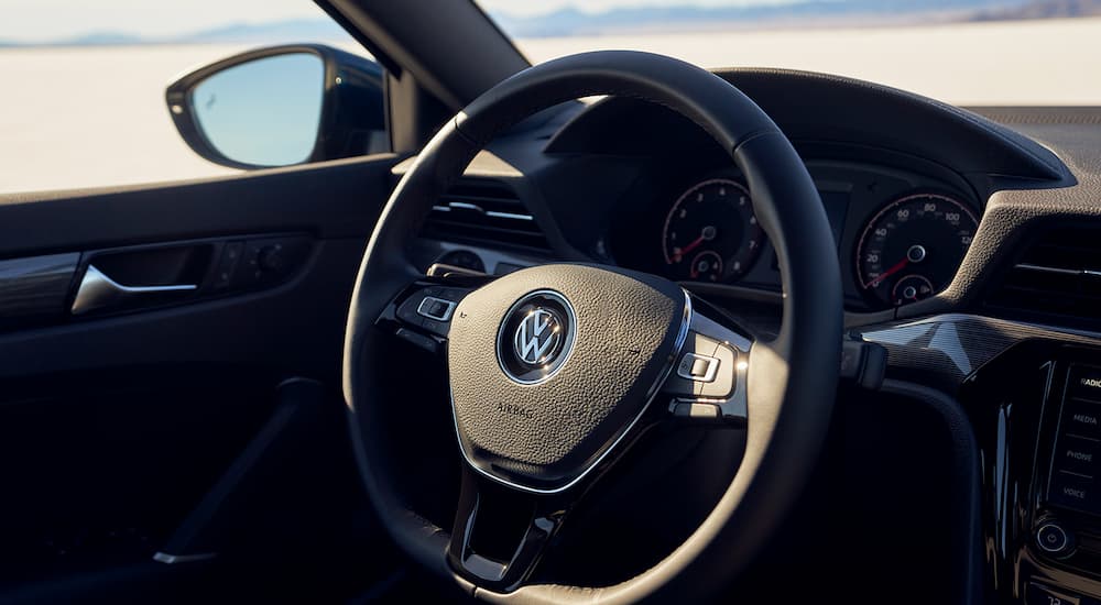 The black interior of a 2022 Volkswagen Passat shows the steering wheel.
