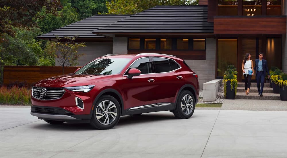 A family is shown walking towards a red 2022 Buick Envision they bought from a Buick dealership.